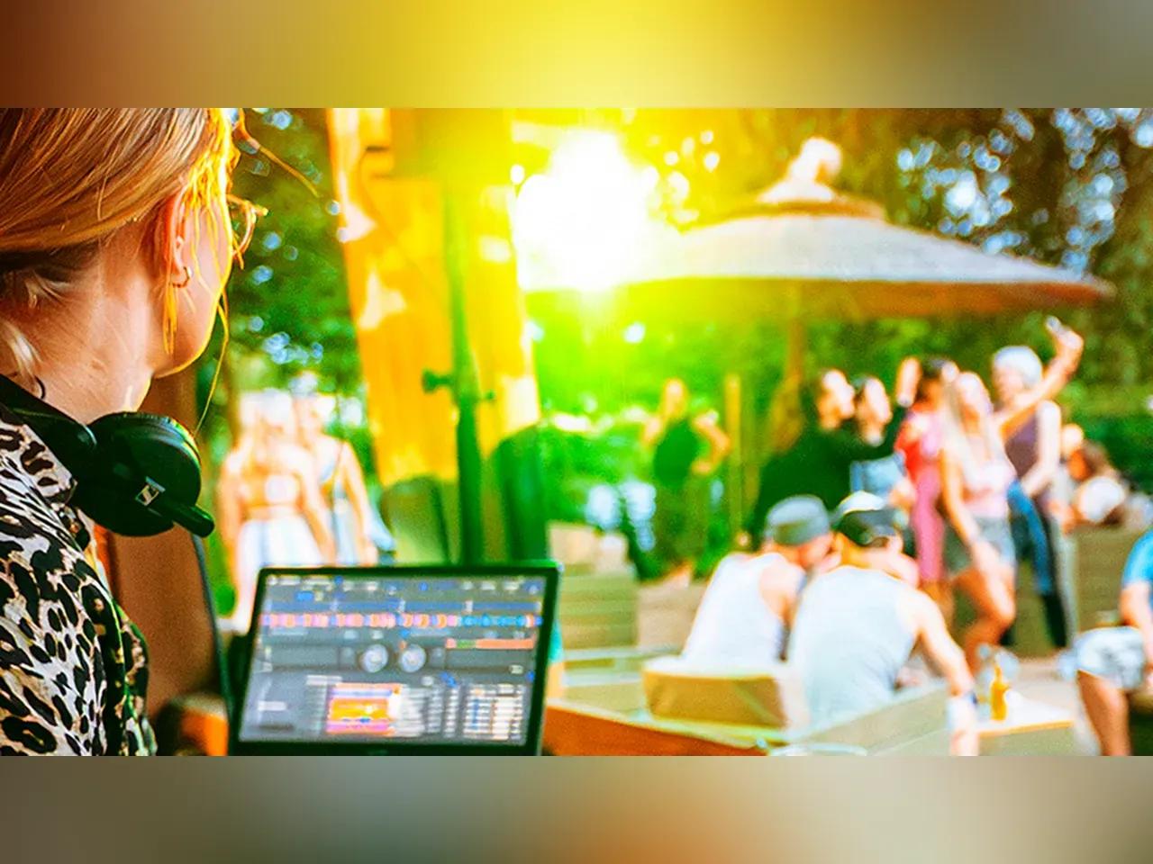 DJane mit Laptop an der Strandbar