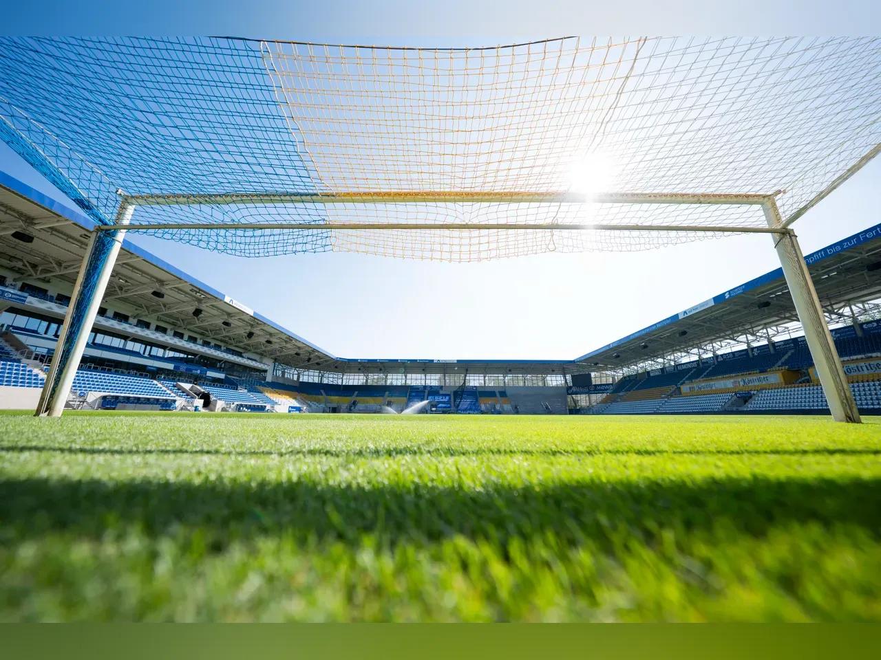 Blick vom Fußballtor auf den Platz bei Sonnenschein