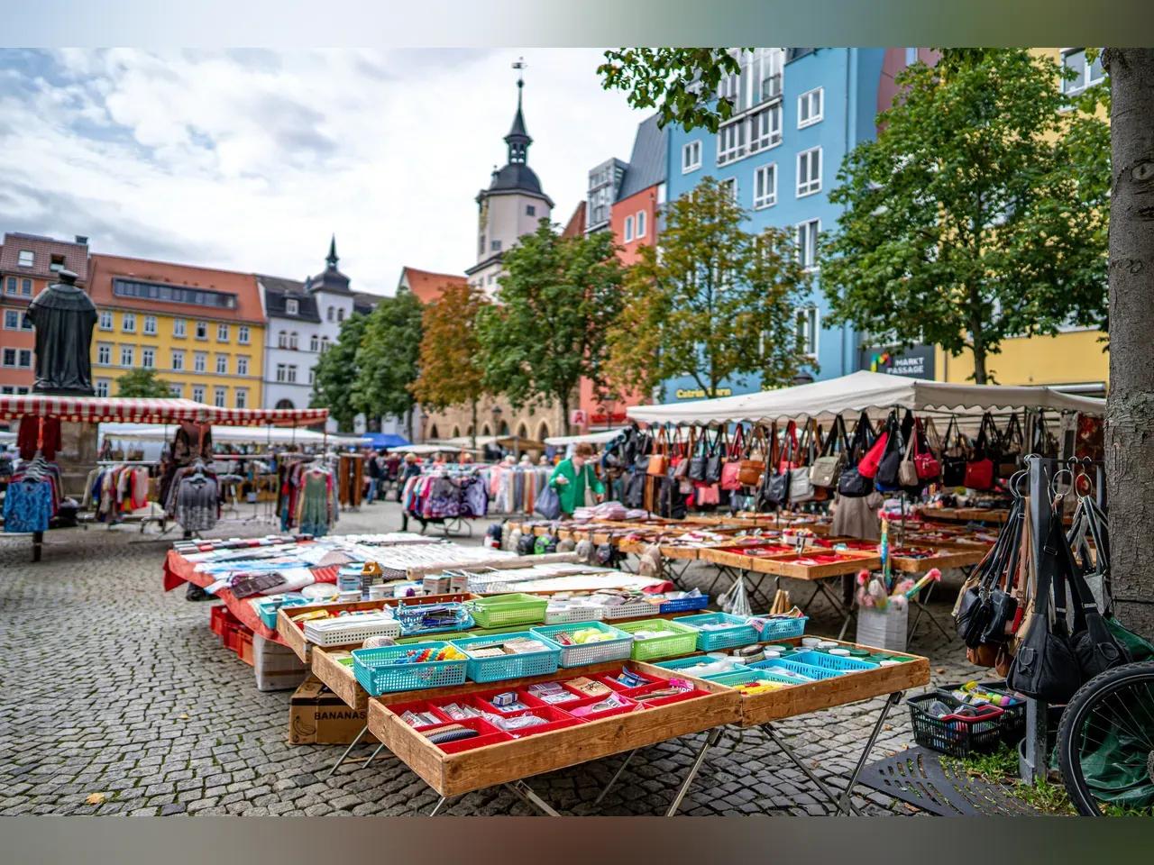 Stand auf dem Marktplatz mit Haushaltsgegenständen und Taschen