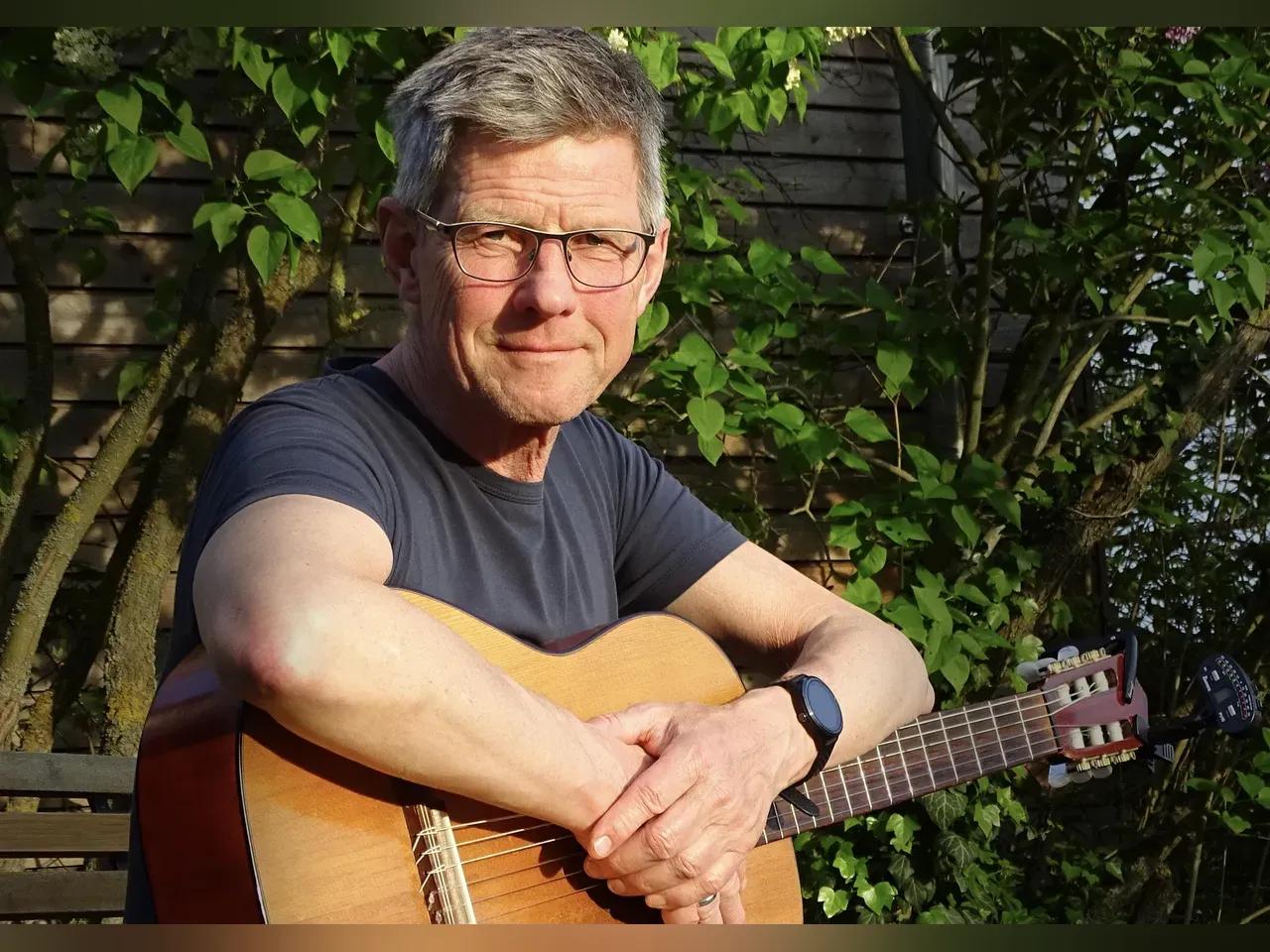Portrait Michael Selle mit Gitarre im Sonnenlicht