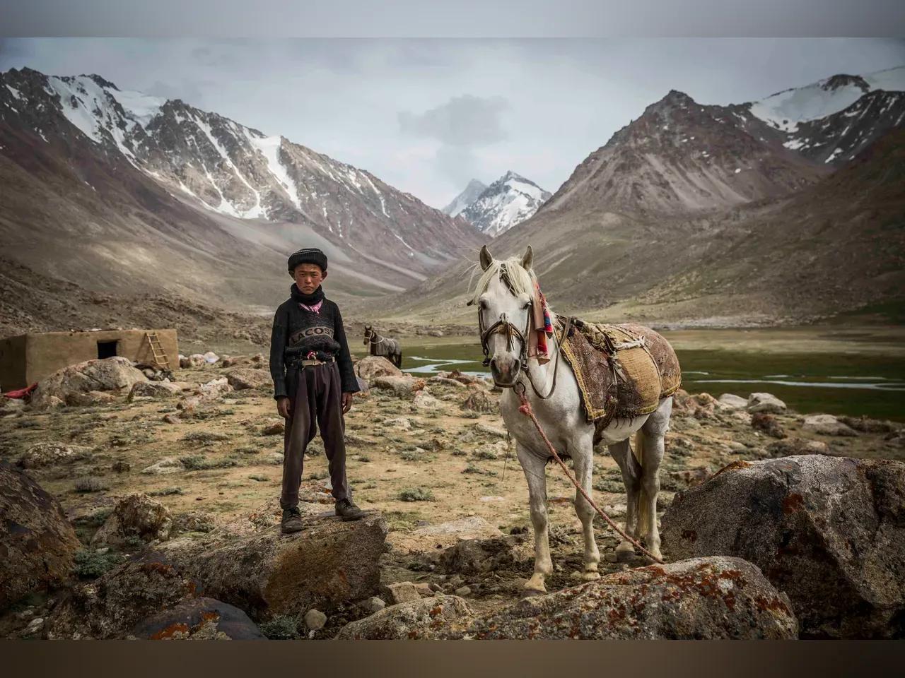 Ein Mensch mit einem Pferd in einer bergigen Landschaft