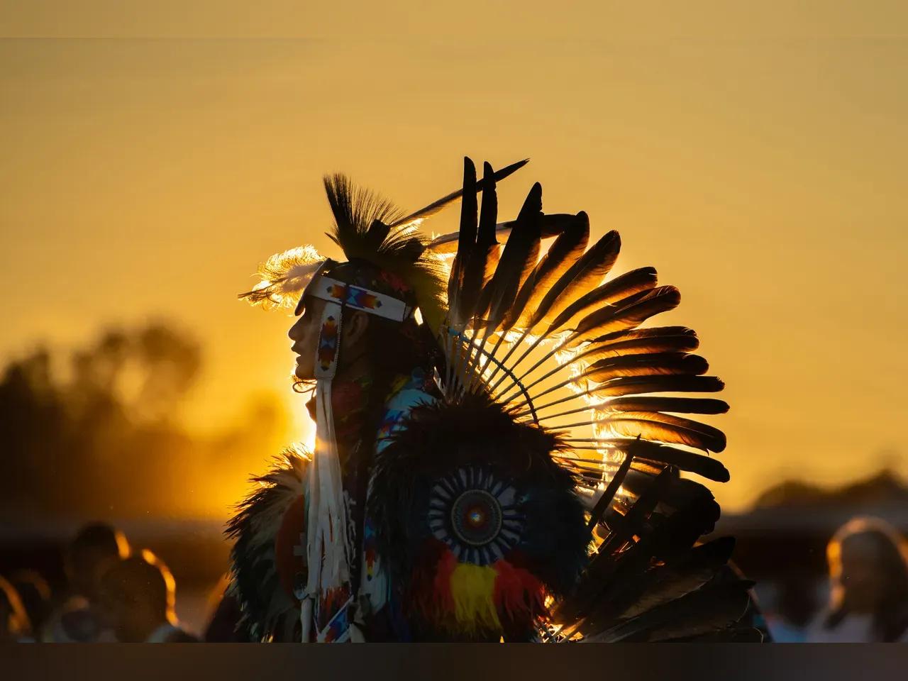 Mensch mit traditioneller Kleidung vorm Sonnenuntergang