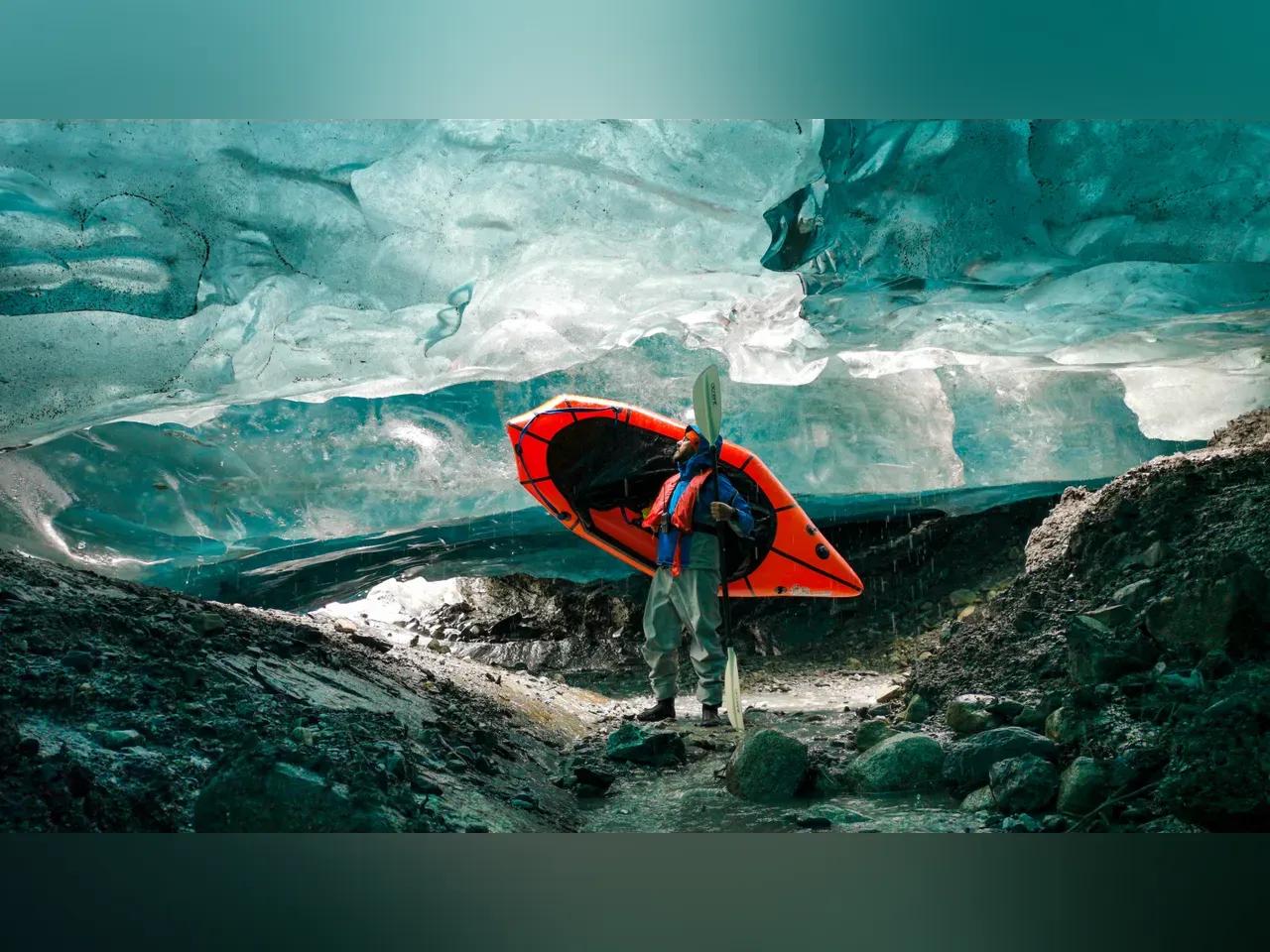 Ein Mensch mit einem kleinen Boot in einem Gletscher