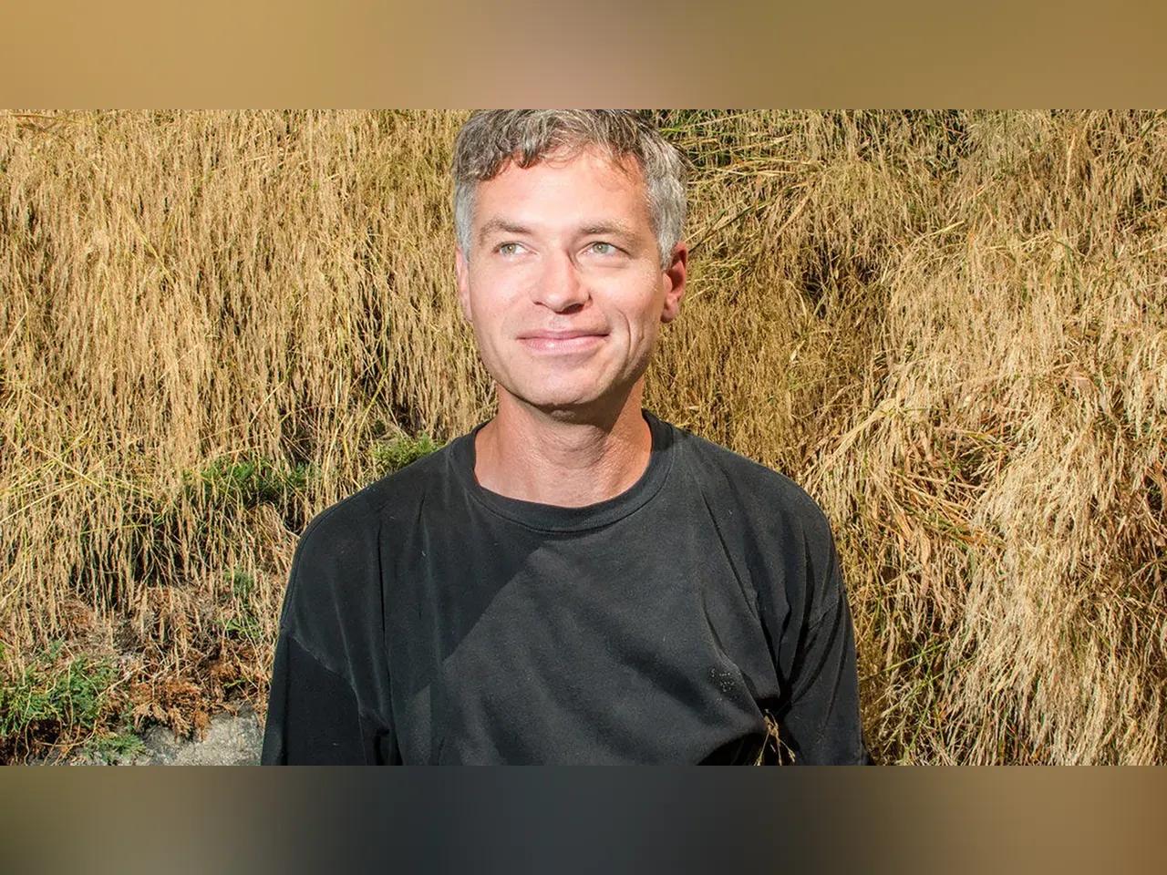 Porträt von Musiker Nicholas Krgovich mit Stroh im Hintergrund