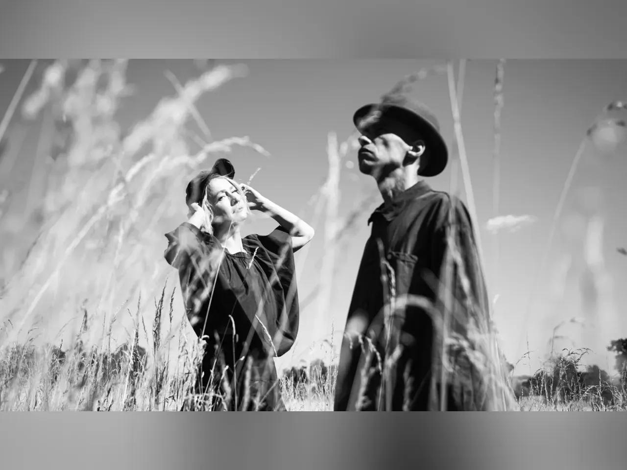 Schwarz-Weiß-Aufnahme der zwei Musiker:innen von Kiiōtō in einem Feld
